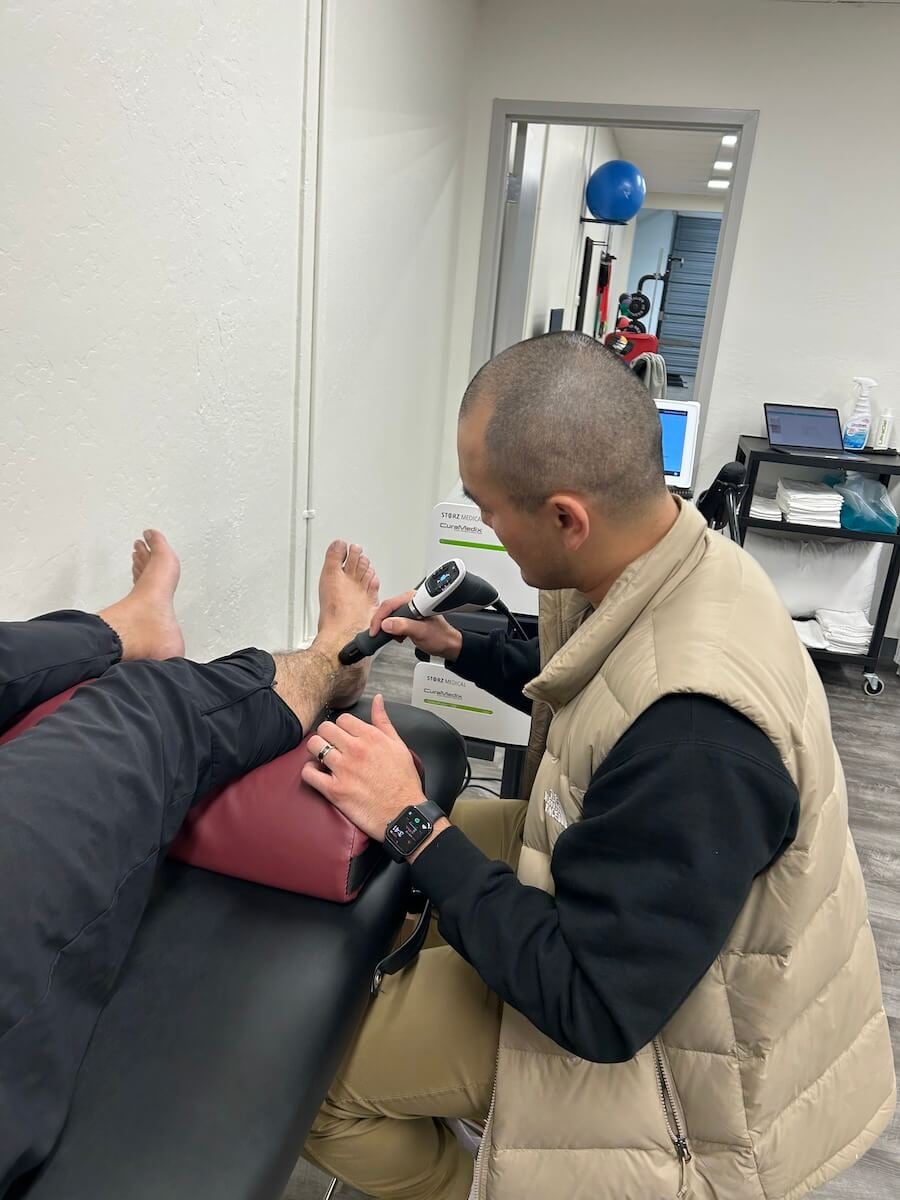 Shockwave therapy being applied on an ankle